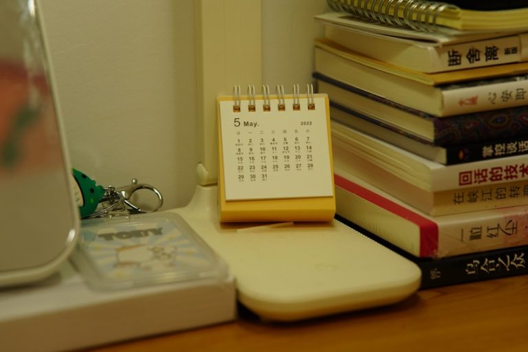 Um Pequeno Calendario De Mesa Fica Ao Lado De Uma Pilha De Livros 211NmLyOzYU